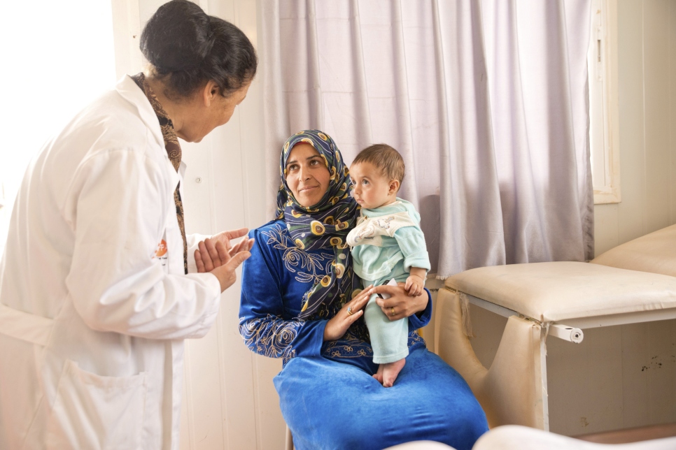 Una madre y su bebé están en consulta en una clínica especializada en mujeres y niñez en Za'atari (2013).