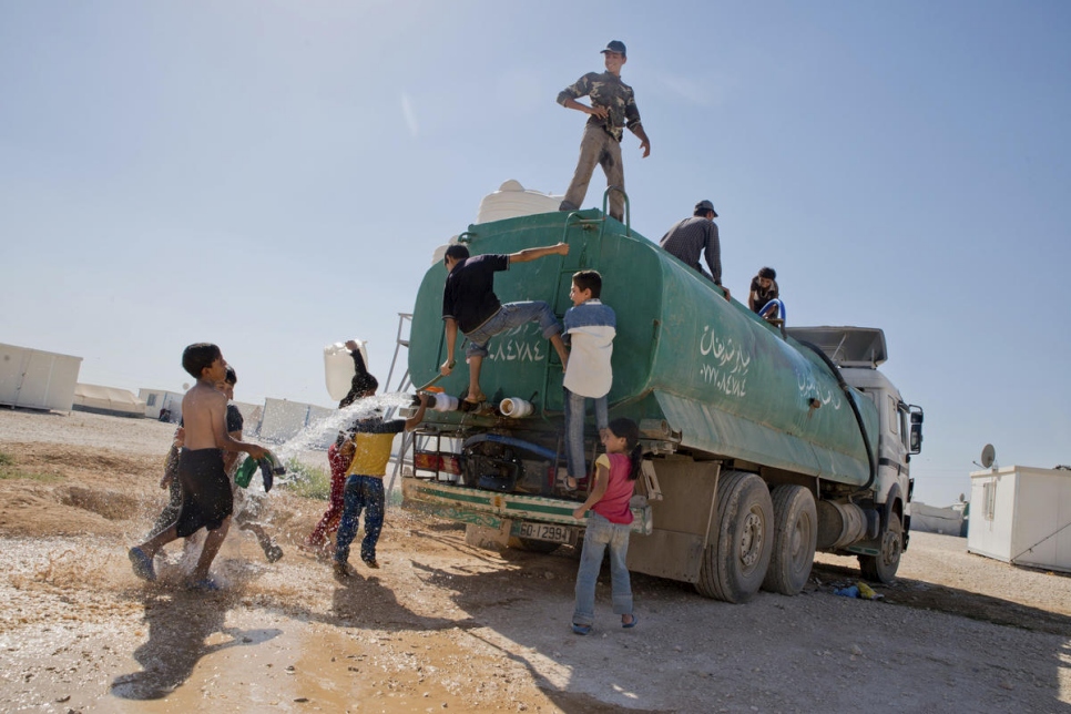 Jóvenes de Siria juegan sobre un tanque de agua que solía ser la principal fuente de agua del campamento (verano del 2013).