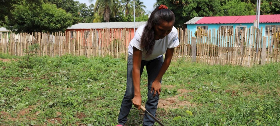 Miembro de la red de mujeres y participante en el huerto preparando la tierra para la siembra