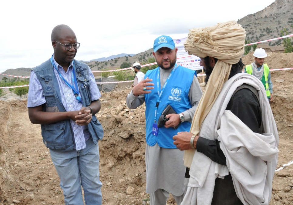 El Representante de ACNUR, Leonard Zulu (a la izquierda) habla sobre la construcción con un hombre mayor (a la derecha) en la aldea de Raghzai, en el distrito de Barmal, Afganistán.