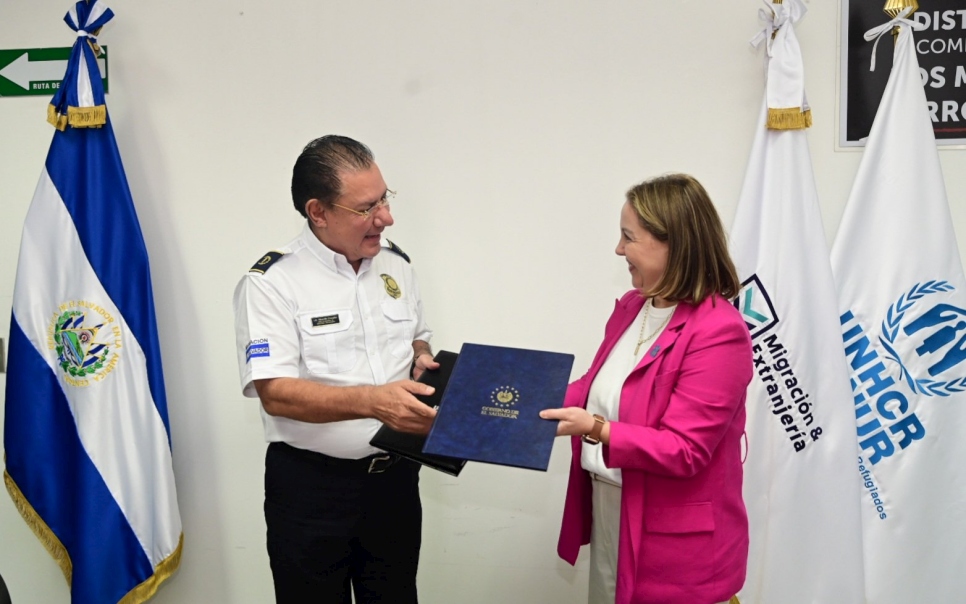 El Director Nacional de Migración y Extranjería, Ricardo Cucalón y la Representante de ACNUR en El Salvador, Laura Almirall durante la firma de la Carta de Entendimiento.