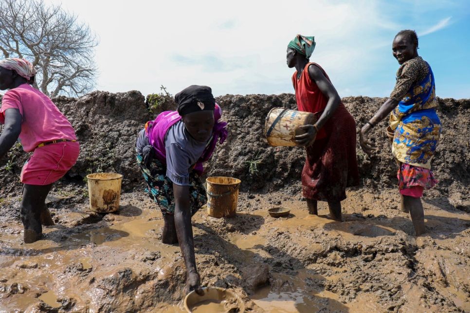 Mujeres de un asentamiento para personas desplazadas internas cerca de Bentiu limpian el agua de una carretera utilizada para llevar ayuda al campamento.