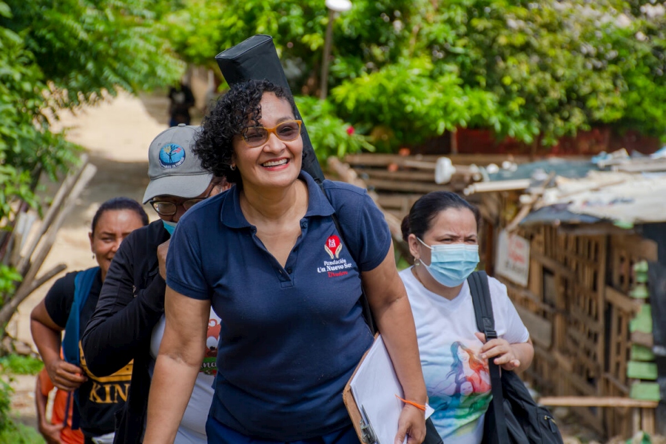 Gloria Inés Padilla Benítez, directora de la Fundación Un Nuevo Ser, camina con personas refugiadas y migrantes en el asentamiento Villa Caracas, en Barranquilla, Colombia.