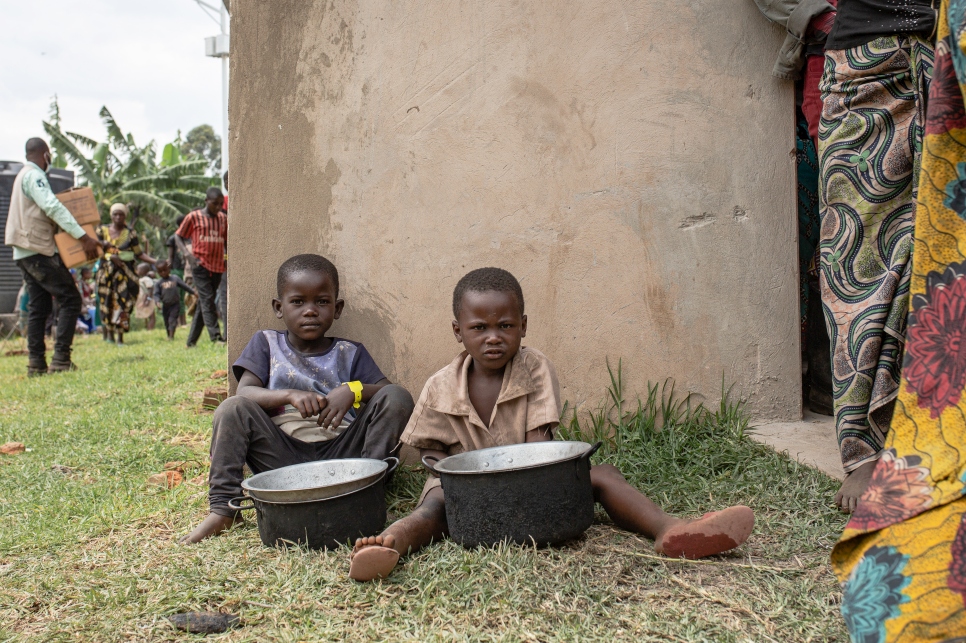 Dos niños esperan por comida en el centro de tránsito de Nyakabande en Kisoro, Uganda, después de unirse a miles de personas que huyen de los combates en el territorio de Rutshuru, en la República Democrática del Congo, a principios de noviembre.