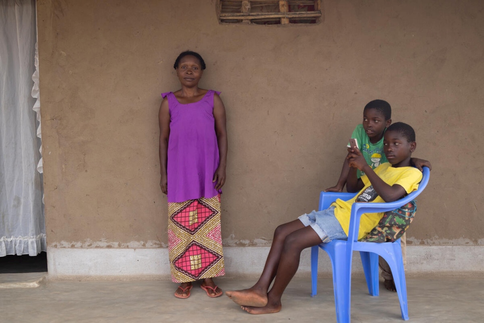 Neema Cenga, quien llegó a Mozambique en 2003 tras huir de la violencia en la República Democrática del Congo, con dos de sus ocho hijos frente a su casa en el asentamiento de refugiados de Marratane.