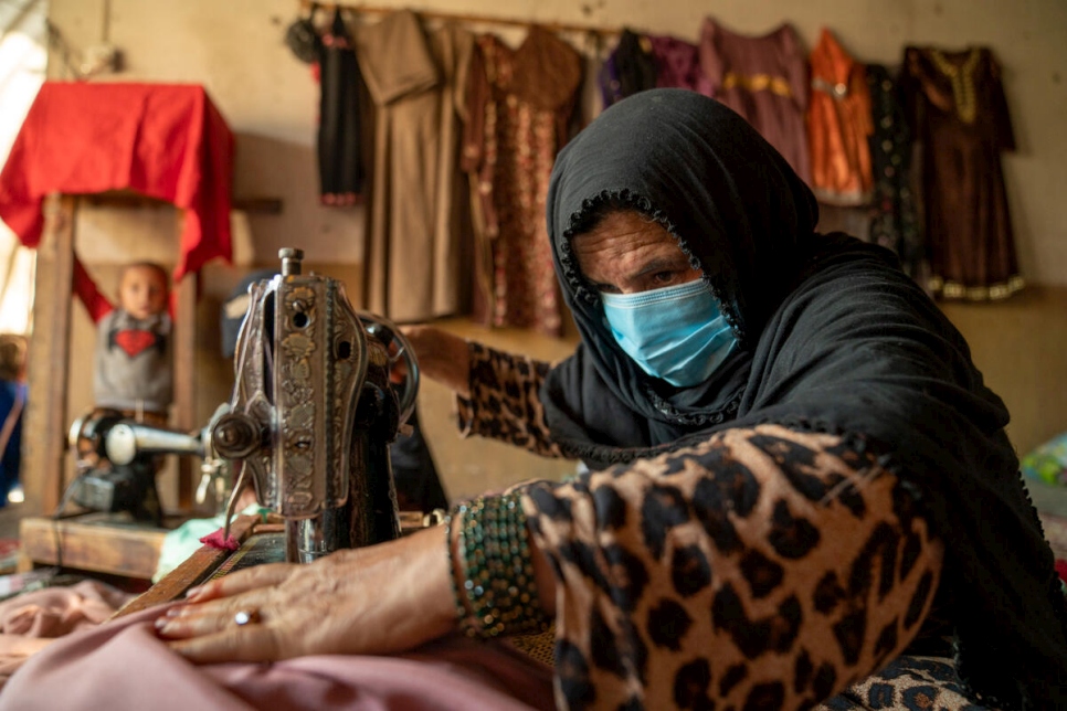 Una desplazada interna que vive en la ciudad de Jalalabad, en la provincia de Nangarhar, confecciona una prenda para una clienta. Estableció un servicio de sastrería desde su casa con el apoyo de un proyecto de medios de vida de ACNUR.
