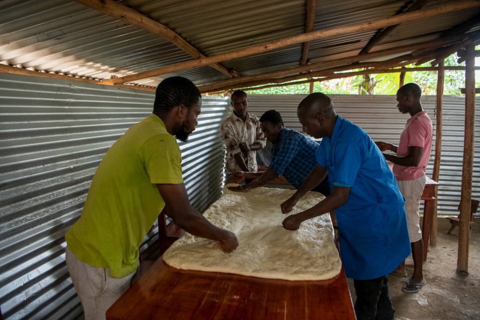 Shebulike y sus empleados y aprendices preparan la masa en su panadería del campamento.