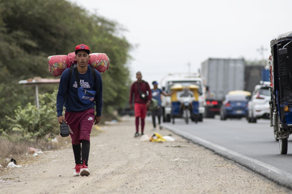 Angelo, venezolano de 22 años, camina por la carretera Panamericana hacia Tumbes, en Perú, en diciembre de 2021.