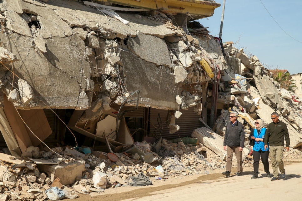 El Alto Comisionado de la ONU para los Refugiados, Filippo Grandi (a la izquierda), camina frente a edificios destruidos en Hatay, Türkiye, durante una visita de tres días al país en marzo.