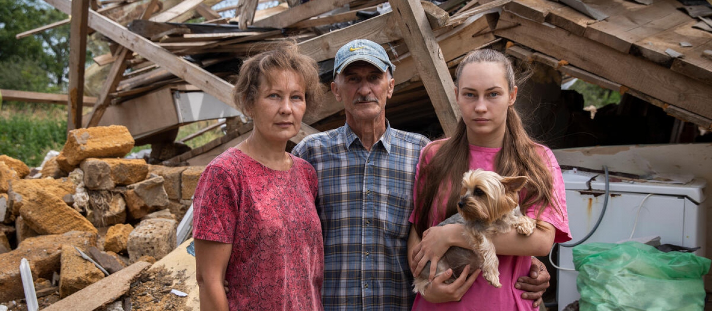 Oksana, Yurii y Svitlana frente a su casa, que fue destruida, en Nalyvaikivka, en la óblast de Kiev.
