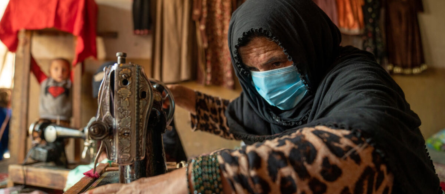Una desplazada interna que vive en la ciudad de Jalalabad, en la provincia de Nangarhar, confecciona una prenda para una clienta. Estableció un servicio de sastrería desde su casa con el apoyo de un proyecto de medios de vida de ACNUR.