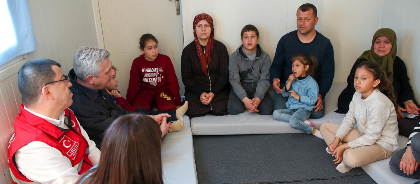 Filippo Grandi está sentado junto a la familia de Ahmet Erkan