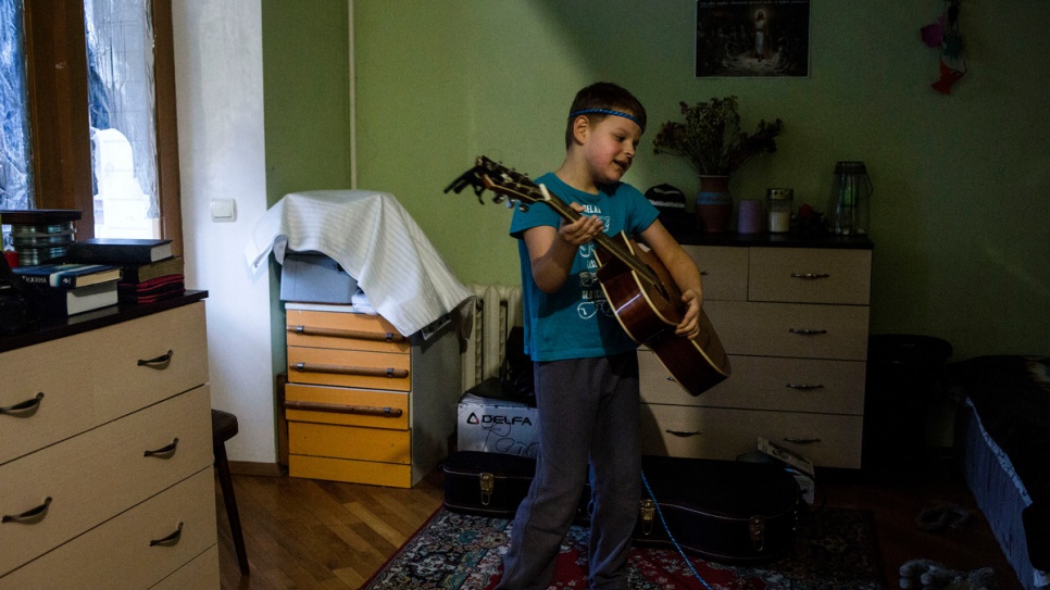 Igor imita a su padre tocando la guitarra en su hogar en Kiev.