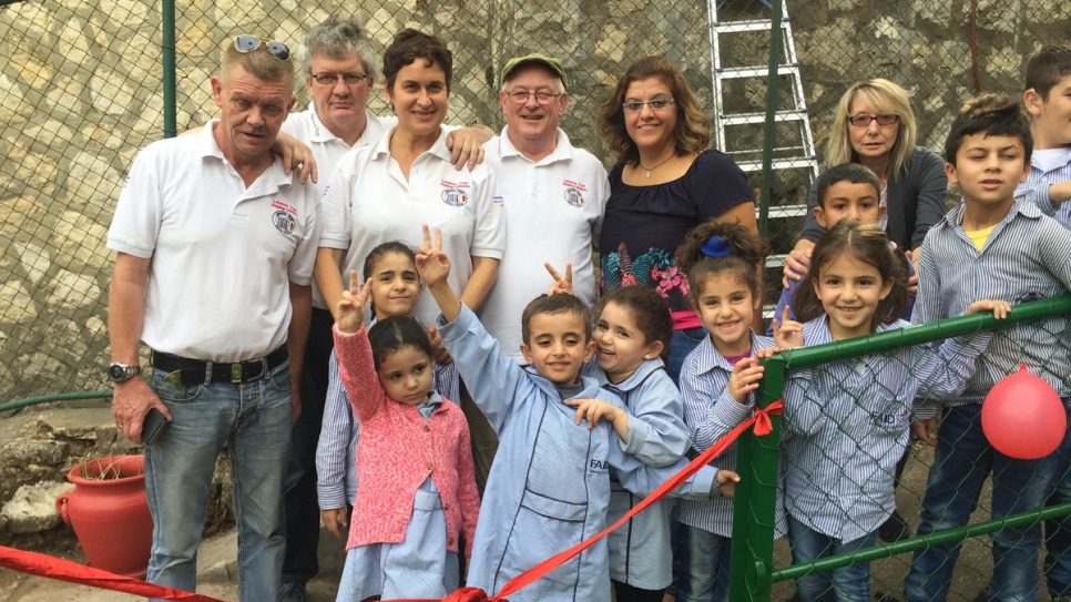 Christy Kinsella (sombrero), presidente del Líbano Trust con otros en el patio de recreo de FAID.