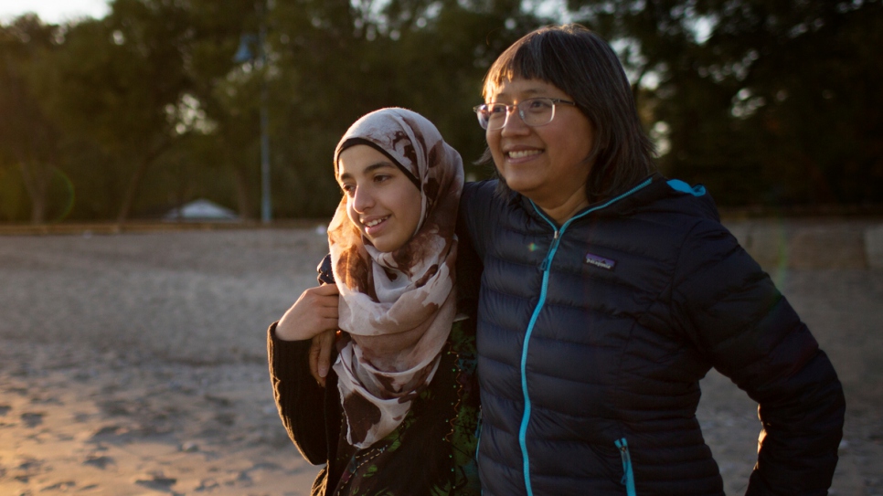 Thuy Nguyen y Narjes Numan pasan tiempo juntas en una playa del centro de Toronto. La Sra. Nguyen llegó como refugiada hace más de 40 años y ahora se desempeña como mentora de la recién llegada Narjes.