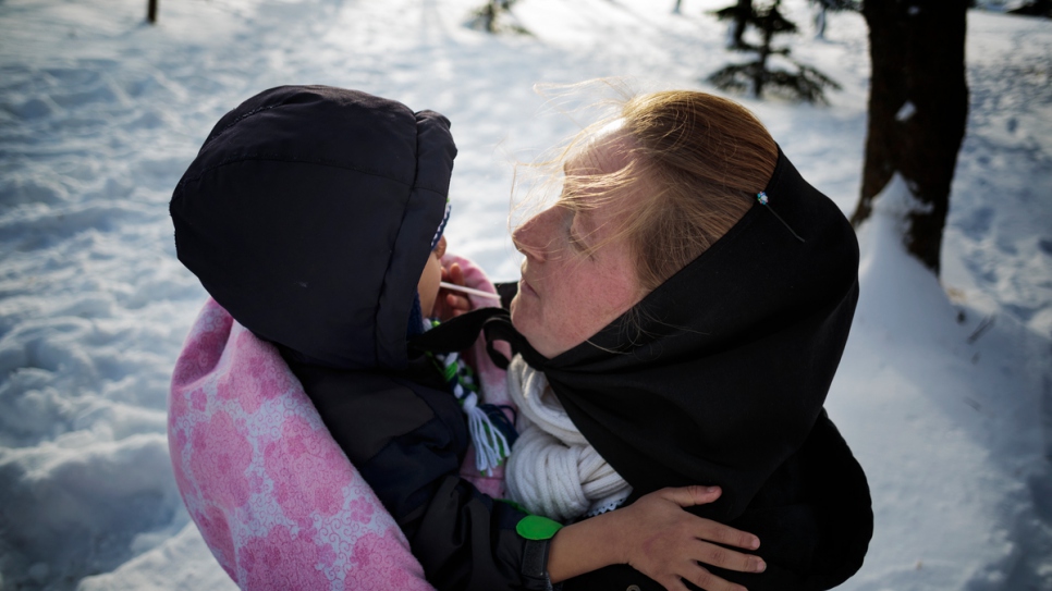 Elaine Hofer cubre a Ali Al Hamoud con una manta después de que la niña siria pasara la tarde jugando en la nieve.