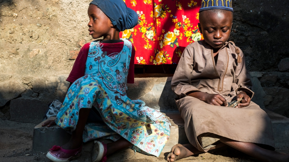 Dos de los nietos de Rahema sentados en el umbral de su hogar en Uvira. Huyeron de Burundi con su abuela tras el asesinato de dos de los hijos de ella. Ahora, cinco miembros de la familia viven en dos pequeñas habitaciones alquiladas, luchando por salir adelante.