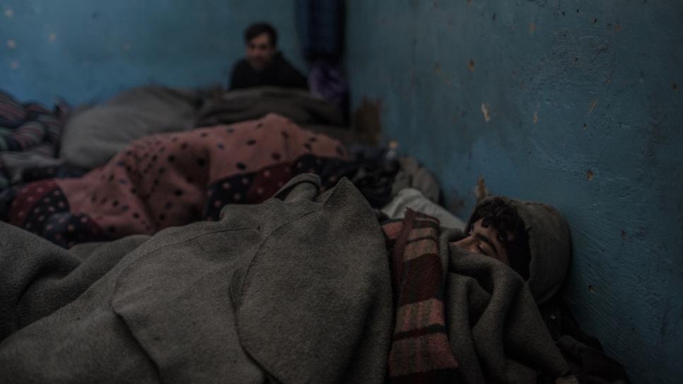 Un refugiado afgano se despierta bajo las mantas tras pasar la noche en un almacén de Belgrado a temperaturas bajo cero.