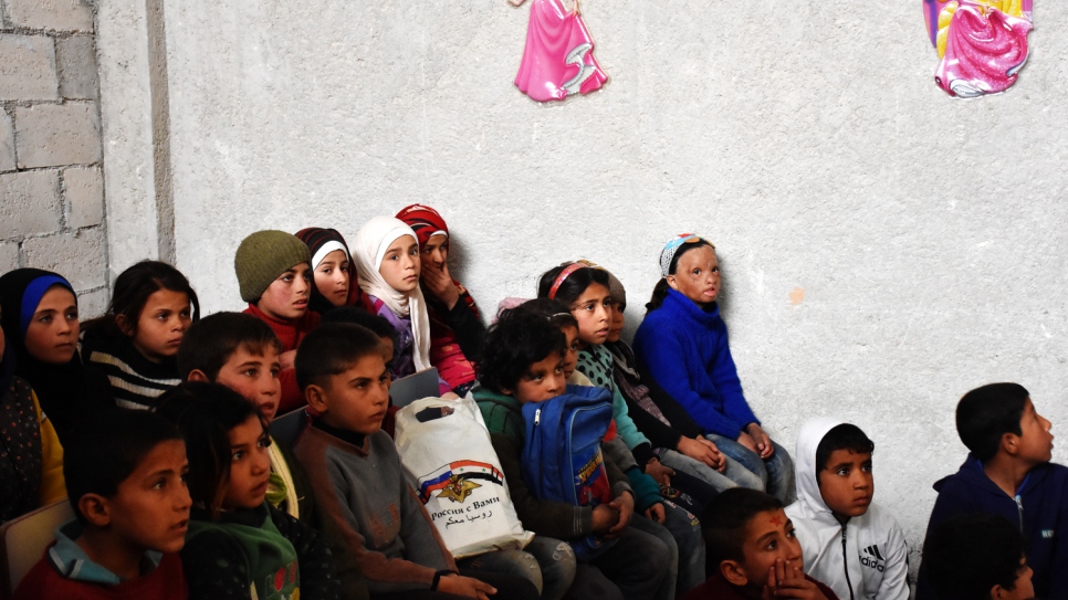 Wafaa, en azul, se sienta con sus compañeros de clase, que han sido desplazados por los seis años de guerra en Siria.