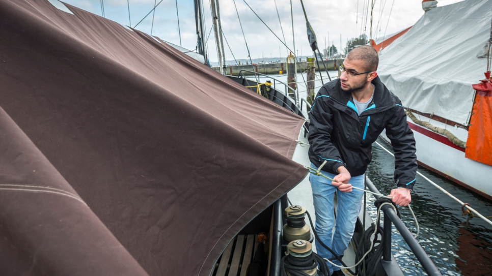 Yousef ata la cubierta de un barco que reparó con su padre Mohammed en la compañía costera Coastworxx de Kiel.