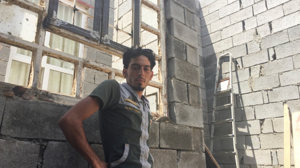 Ibrahim Khalil, un jornalero y conductor de grúas de 25 años, cerca de una ventana rota en su casa, cuyo techo se encuentra a cielo abierto.