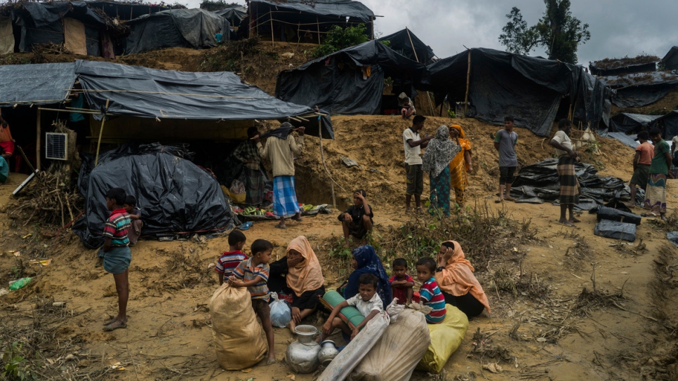 Una familia refugiada Rohinyá espera mientras busca un espacio para vivir en el asentamiento en Thangkali, Bangladesh.