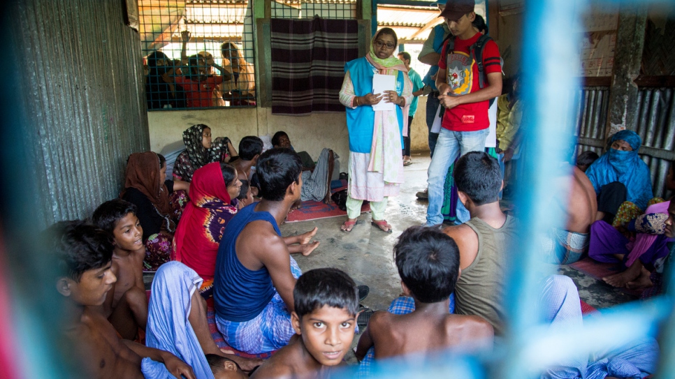 Mahmuda habla con los supervivientes del naufragio de Rohingya que han perdido familiares cuando el bote volcó en la playa de Inani, al lado de Cox's Bazar, en Bangladesh.