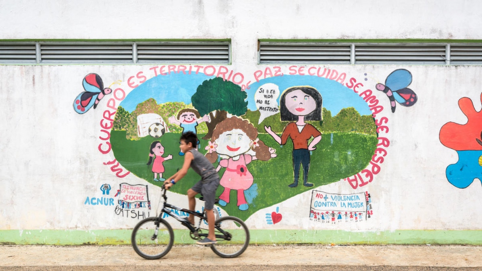 Un niño pasa junto a un mural con un mensaje de paz en la comunidad de Nueva Esperanza, que alberga a 228 familias desplazadas por el conflicto armado en Colombia.