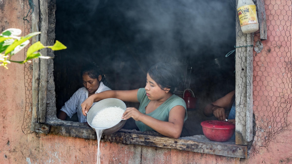 Aida Johana, 19 años, cocina el almuerzo para su familia en la casa de Armando Pai. Como líder comunitario, Armando tiene la única cocina que funcione en toda la comunidad. Aida, como las otras 16 familias del asentamiento, vive en una cabaña techada con bolsas plásticas.