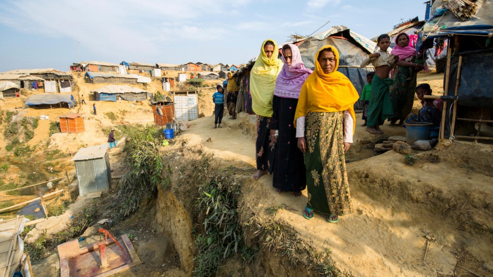 Siraj Begum, de 38 años, con pañuelo amarillo, Mariam Khatun, de 60 años con pañuelo morado y Nur Nahar, de 45 con pañuelo naranja fuera de su albergue en el campamento de refugiados de Kutupalong en Bangladesh. Su hogar se encuentra en una ladera empinada de una colina en riesgo de derrumbe por el monzón.