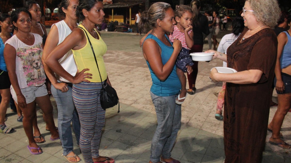 Ana Lucíola Franco (derecha) distribuye comida a los venezolanos que acampan en la plaza Simón Bolívar, en Boa Vista, Brasil.