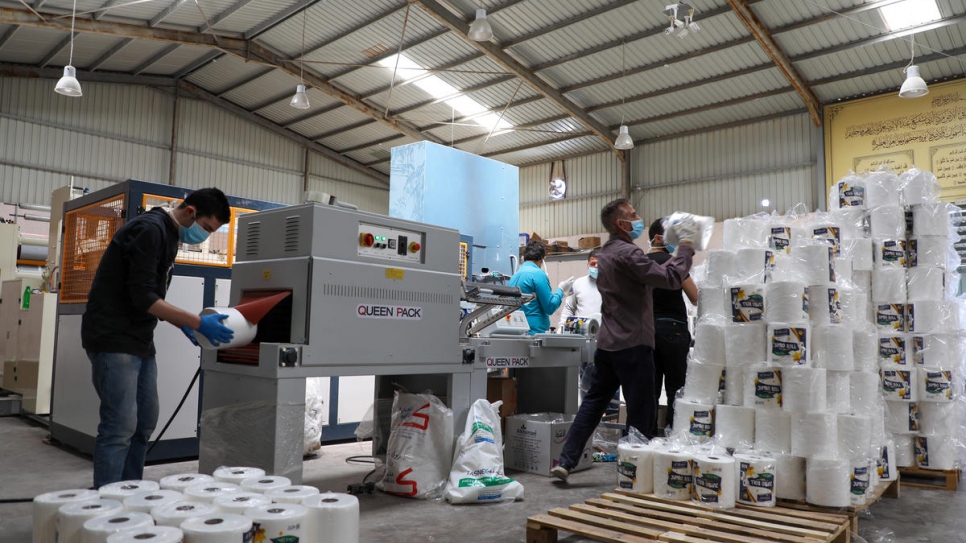 Trabajadores, entre ellos refugiados sirios, empacan servilletas en la fábrica de Al Khamel en el suburbio de Sahab,en Amán, Jordania.