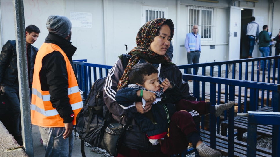 Una solicitante de asilo de Afganistán carga a su hijo al ingresar al área de registro del centro de Recepción e Identificación de Moria, en la isla griega de Lesbos.