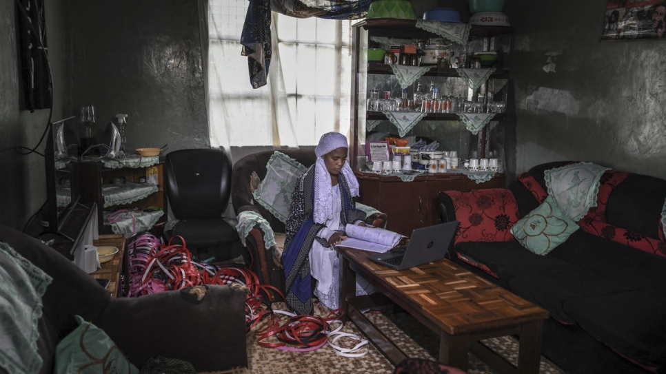 Nosizi Reuben, una mujer apátrida de 20 años de edad, revisa su computadora portátil en su casa en Kinoo, Kenia.