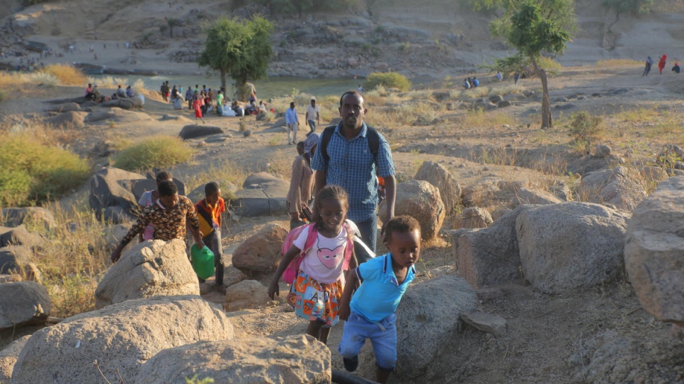 Refugiados etíopes caminan por terreno rocoso para llegar a Hamdayet, Sudán.