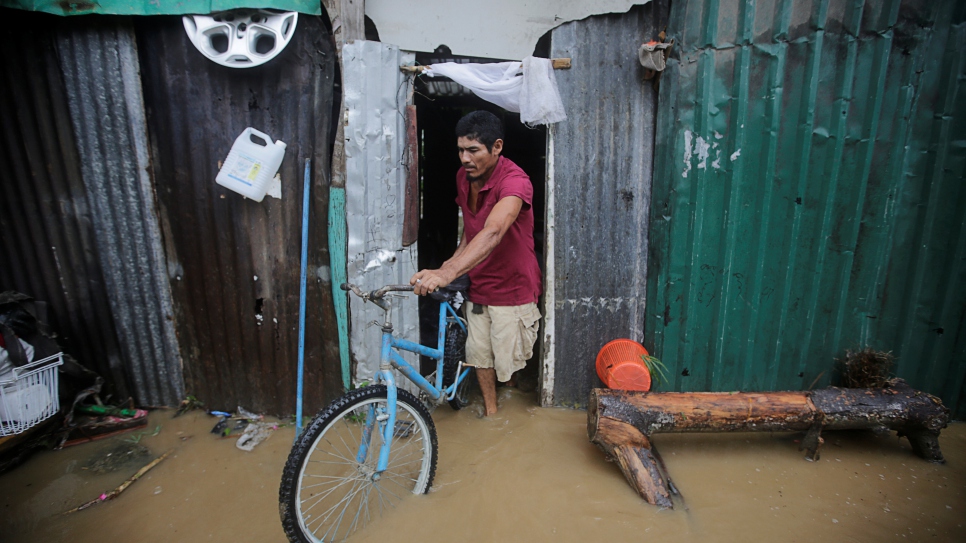 Un hombre sale de su casa, afectada por las inundaciones provocadas por el paso del Huracán Eta en Tela (Honduras), el 4 de noviembre de 2020.