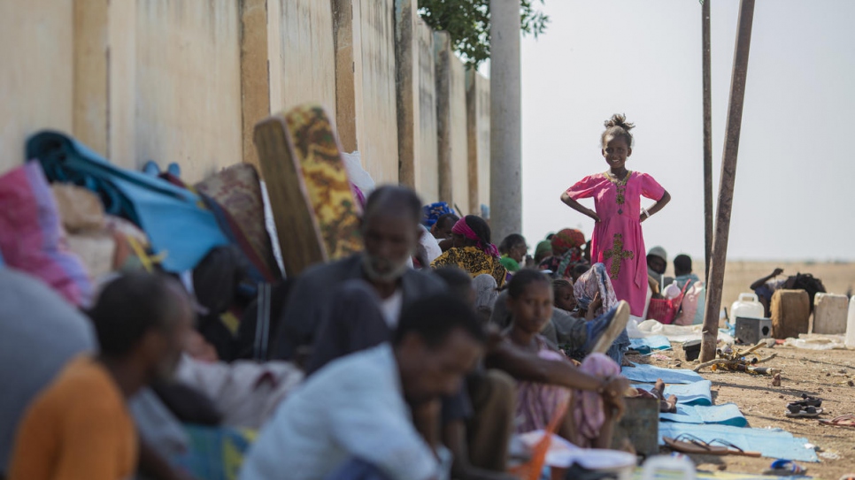 Refugiados de Etiopía sentados a la sombra para protegerse del sol de la tarde en el centro de recepción fronterizo de Hamdayet, en el este de Sudán.