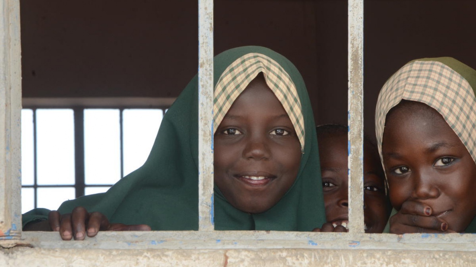 Niñas nigerianas desplazadas miran a través de la ventana de su clase en una de las cuatro escuelas fundadas por el ganador del Premio Nansen para los Refugiados Zannah Mustapha en el Estado de Borno (Nigeria).