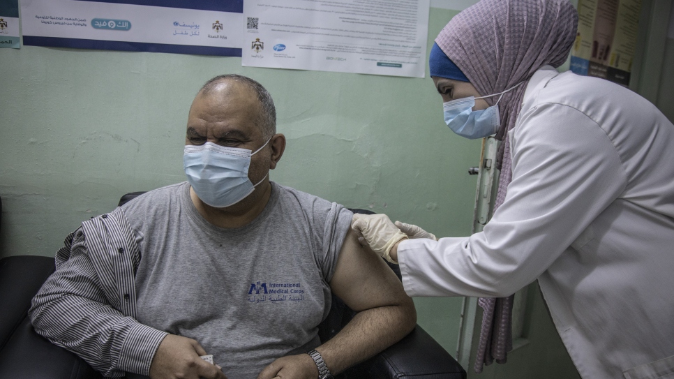 El refugiado iraquí Ziad Al Kabashi recibe la vacuna contra la COVID-19 en un centro de salud en Irbid, Jordania.