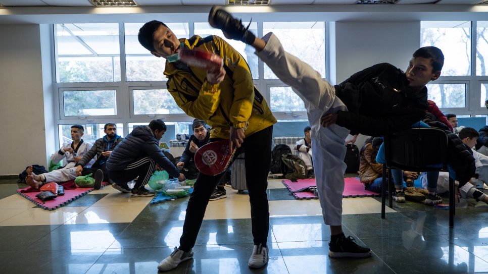 Mukhamadjon y un alumno se preparan para una competencia en la Federación de Taekwondo de Uzbekistán.