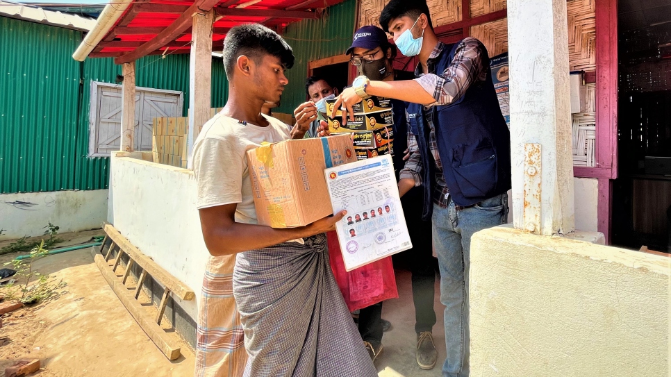Personas refugiadas voluntarias entregan apoyo a las familias afectadas por el incendio en los campamentos de Kutupalong-Balukhali, Bangladesh.