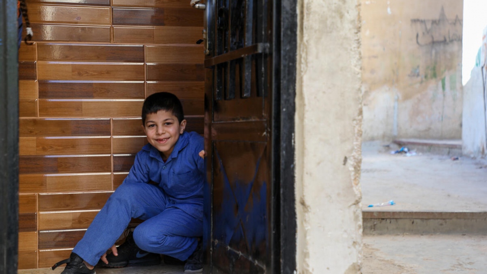 Ahmed de 8 años, hijo menor de Jameela, en la entrada de su apartamento en Ammán, Jordania.