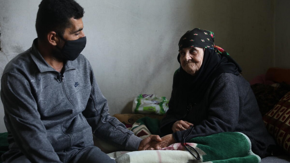 Amina de 85 años, se sienta en la cama con su hijo Abdo en la casa que comparten en Touline, Líbano. 