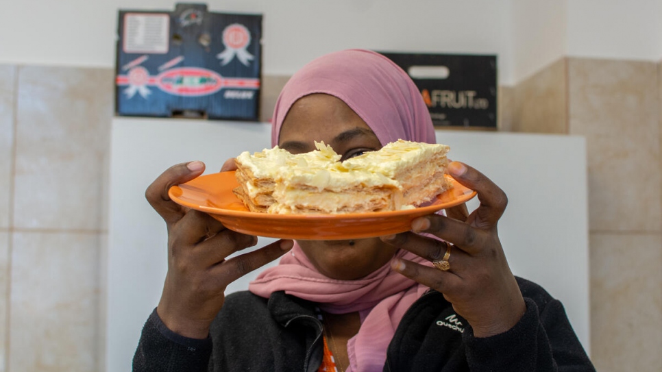 Mariam, de 34 años y originaria de Eritrea, muestra su primer "tompouce", el cual preparó durante un taller de cocina en el Centro de Tránsito de Emergencia en Timisoara, Rumania.