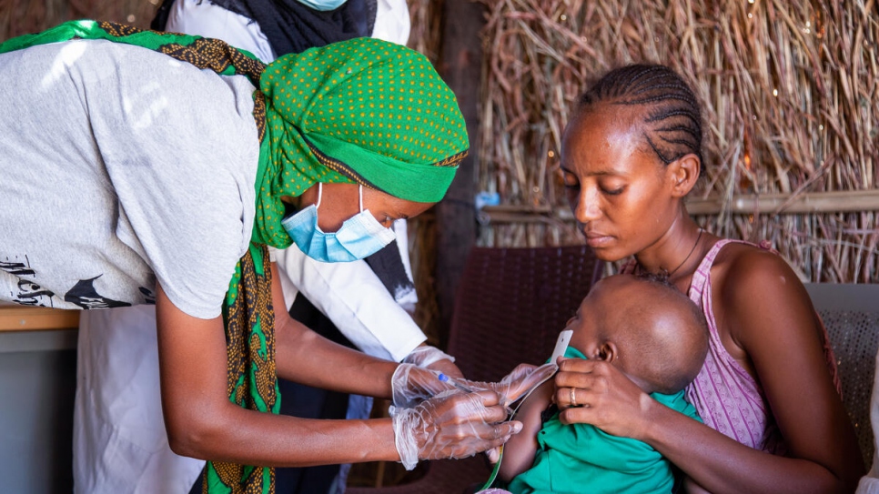 Mihret, refugiada etíope de 25 años, mide los signos de un niño en la clínica en la que es voluntaria en el asentamiento de Tunaydbah, en Sudán.