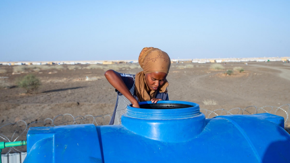 Mihret, ingeniera etíope refugiada, verifica el nivel del agua en un tanque instalado en la base de la oficina móvil en el asentamiento de Tunaydbah, en Sudán.