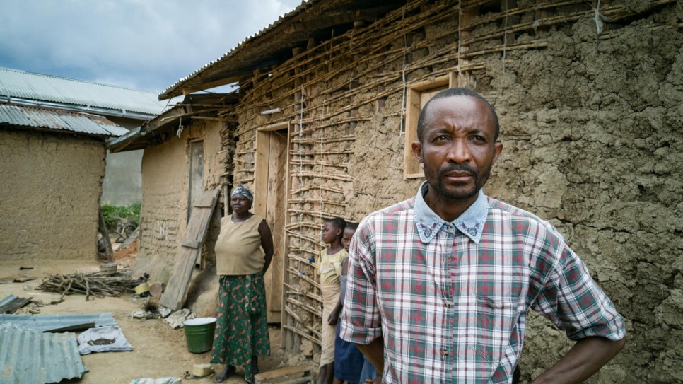 Evan Sikiani, un desplazado congoleño, afuera de las instalaciones de su anfitriona, Kahambu Mwavuli (atrás), donde viven hasta 25 personas en Beni, al noreste de la República Democrática del Congo. 