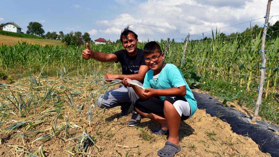 Adel y su hijo de doce años, Sajad, entre cebollas plantadas en la granja de Adel en Bosnia y Herzegovina.