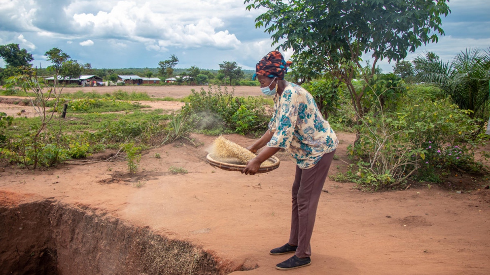 Antoinette, granjera congoleña, cierne arroz en su granja en el asentamiento de Lôvua, en Angola.