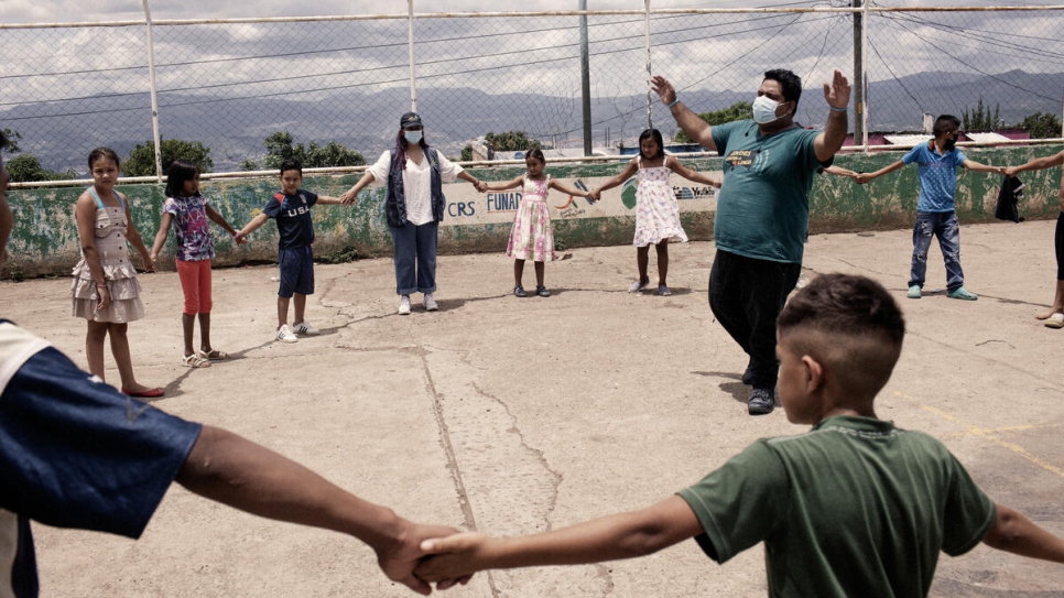 Edras Levi Suazo, responsable de comunicación de Jóvenes Contra la Violencia, organiza una actividad con niñas y niños en Nueva Capital, Honduras. 